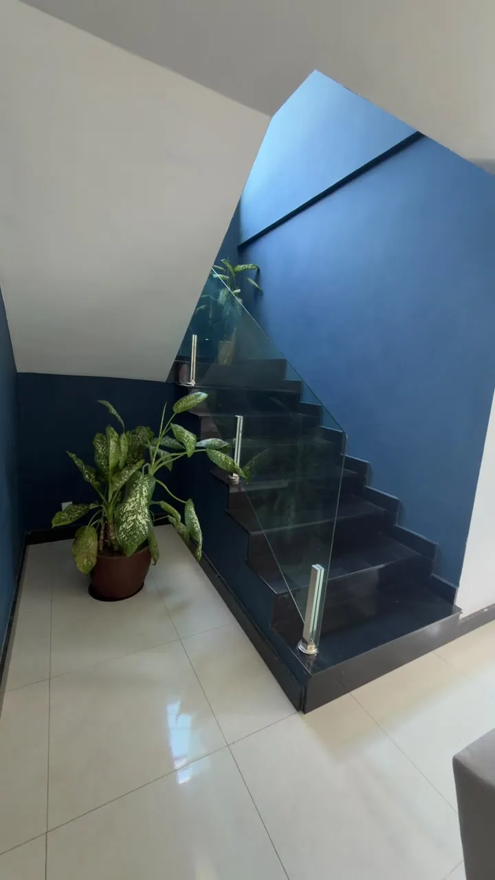 Escada com guarda-corpo de vidro da casa em Carapebus