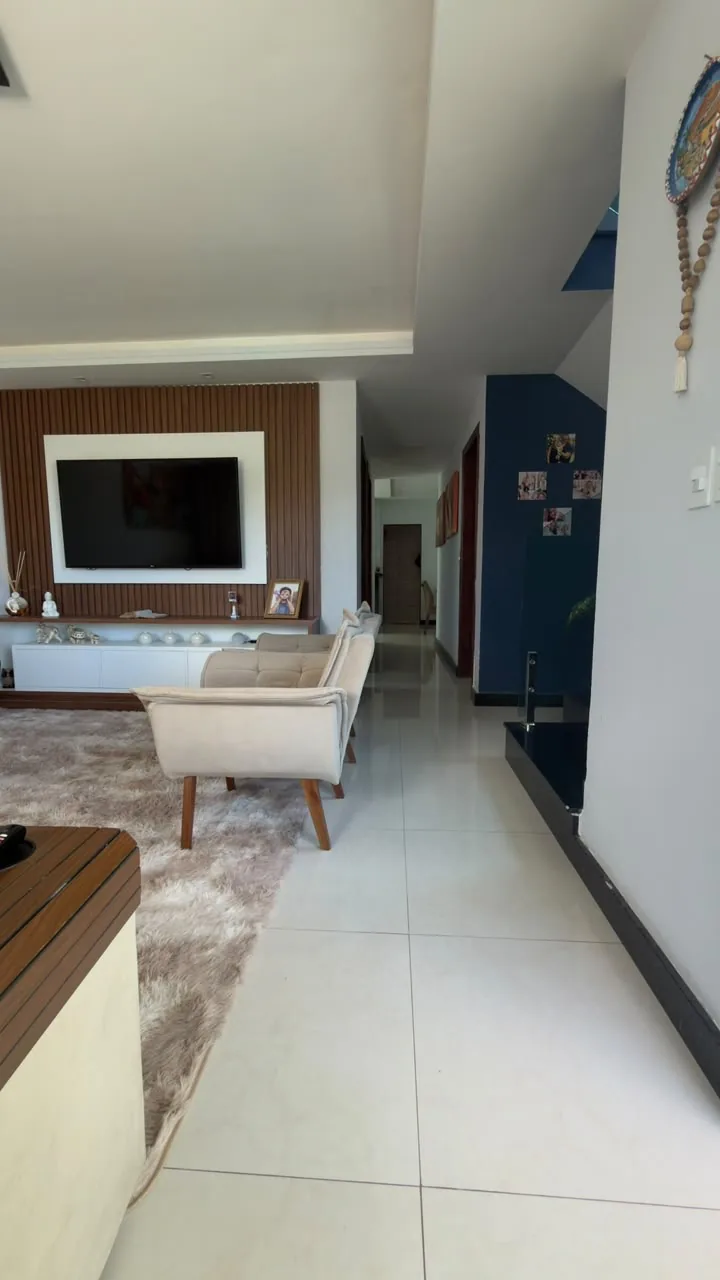 Sala de estar com painel ripado e TV, casa em Carapebus